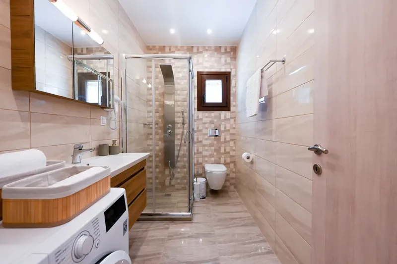 A bathroom with a walk-in shower and washing machine