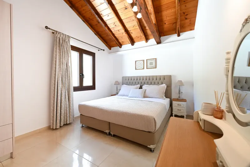 A bedroom under the exposed roof beams