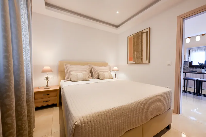 A bedroom with the living room beyond it