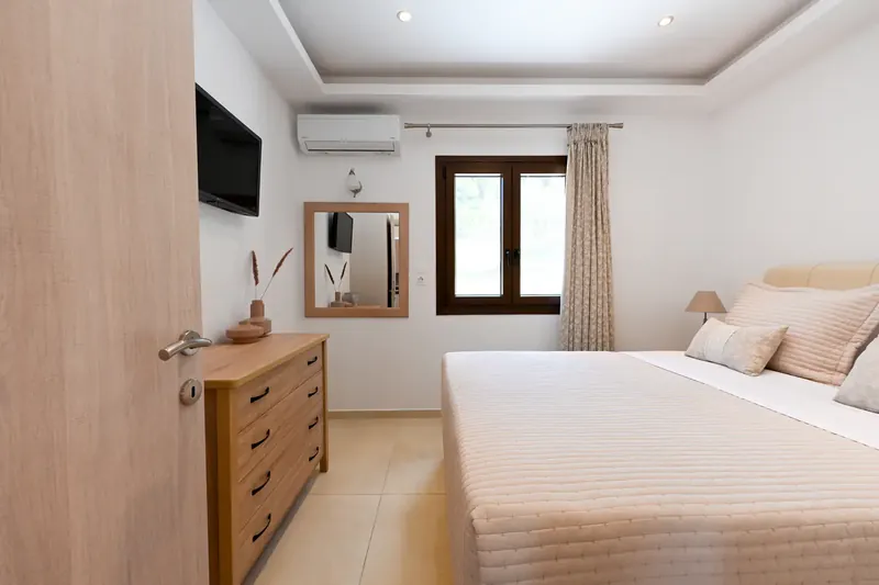 A double bedroom with a chest of drawers and a television