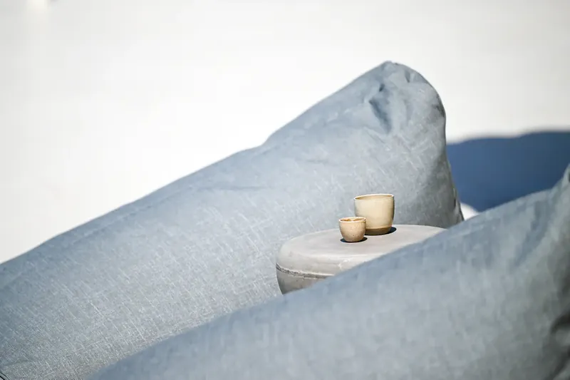 A candle on the arm of the outdoor sofa