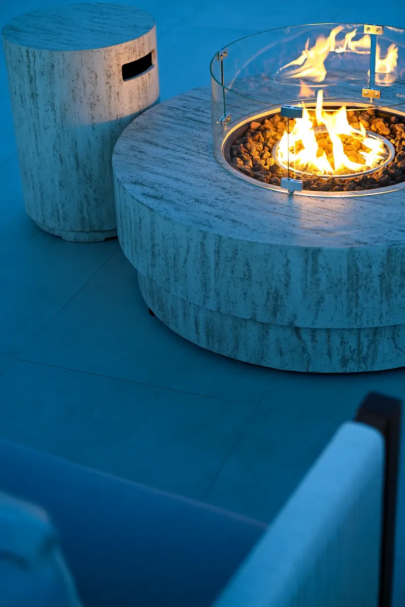 The fire bowl alight beside the blue of the pool