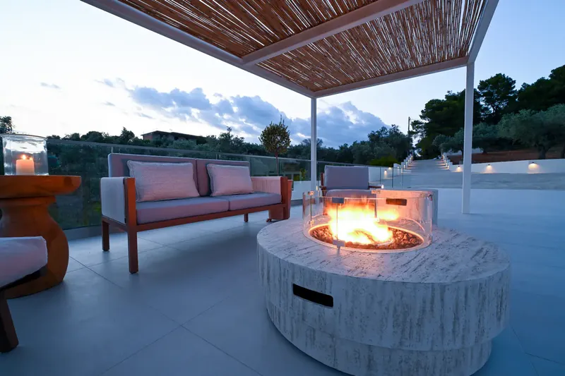 The outdoor lounge and lit fire pit after sunset