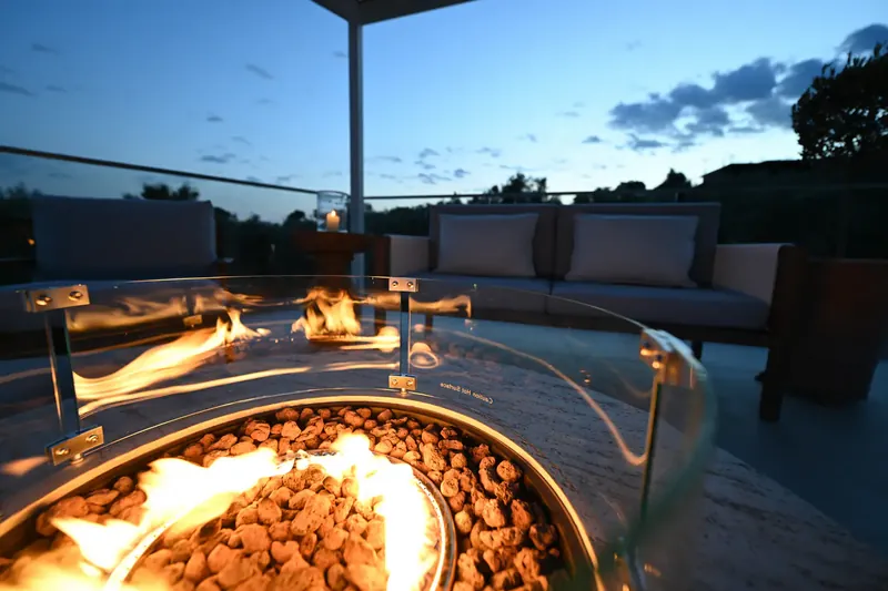 The fire pit burning on the terrace at dusk