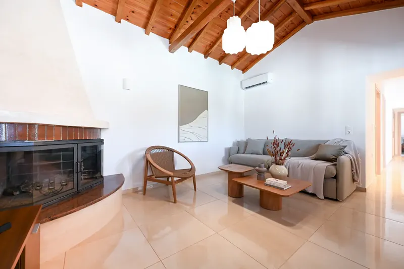 The living room under the timber roof, with the fireplace